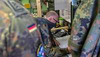 In einer Kabine wertet ein Soldat den ihm gerade übergebenen Bericht des Erkundungsfeldwebel aus