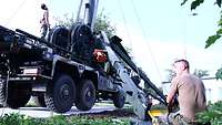 Zwei Soldaten arbeiten am Aufbau der Antennenmastanlage