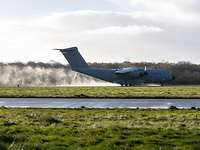 Ein A400M landet auf einer nassen Landebahn