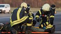 Feuerwehrleute arbeiten während einer Übung an einem verletzten Passagier