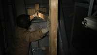 Ein Soldat stützt mit einer Holzkonstruktion ein simuliertes Loch im Rumpf des Schiffes