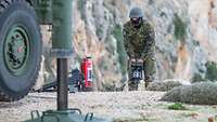 Ein Soldat bedient die hydraulischen Standfüße des Launchers beim Aufbau