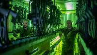 Zwei Soldaten stehen in der Waffenkammer und warten auf die Ausgabe der Gewehre und Pistolen