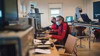 Die Drohnenpiloten sitzen vor ihren Bildschirmen in der Kontrollstation.