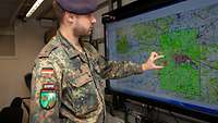 A soldier in front of a digital map.