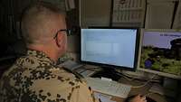 Ein Soldat sitzt vor einem Computer und arbeitet in einem Beschaffungssystem der Bundeswehr