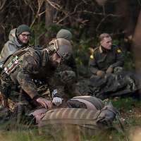 Ein Soldat kümmert sich um einen Verwundeten.