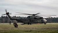 Die CH-53 steht auf dem Landeplatz, der Lademeister steht an der Heckklappe.