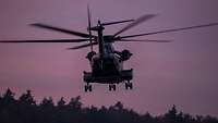 Eine CH-53 fliegt in den Abendhimmel hinein.