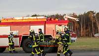 Mehrere Feuerwehrmänner tragen eine Trage mit einem Verletzten