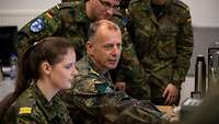 Mehrere Soldaten unterhalten sich an einem Computer