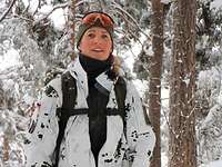 Eine Soldatin in Schneetarnuniform lächelt in die Kamera
