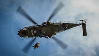 Ein Hubschrauber, von unten betrachtet, fliegt durch die Luft.