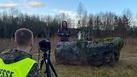 Produktion einer Videoandacht. Die Pfarrerin steht an einem Findling, der als Altar dient.