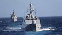 Zwei Kriegsschiffe im Wasser, sie fahren hintereinander auf dem Meer
