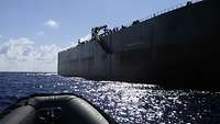 Im Vordergrund die Spitze des Speedbootes und im Hintergrund das anzulaufende Schiff