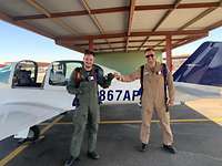 Gabriel steht mit seinem Fluglehrer nach seinem ersten Flug vor der Übungsmaschine und lächelt.