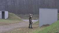 Ein Soldat bläst in ein Schalmeihorn. 