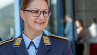 Ein lächelnde Frau mit Brille in blauer Luftwaffenuniform. 