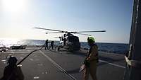 Ein Hubschrauber steht auf dem Flugdeck der Fregatte