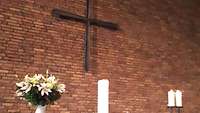 Altar mit Blumen, Kerzen und einem Kreuz im Hintergrund