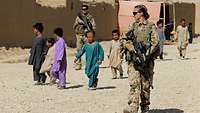 Eine Soldatin läuft während einer Patrouille durch ein Dorf in Afghanistan