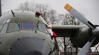 Der Weihnachtsmann schaut aus dem Cockpit des Flugzeuges.