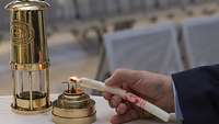 Eine Kerze wird am Friedenslicht aus Bethlehem entzündet