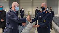 Generalmajor Bernhardt Schlaak übergibt das Friedenslicht an den Piloten Oberstleutnant Dirk Junker
