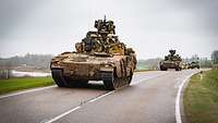 Norwegische Schützenpanzer fahren über eine Landstraße in Litauen