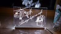 Geschenk zum Abschied: Plexyglasscheibe mit eingraviertem Hubschrauber und Radarkonsole.