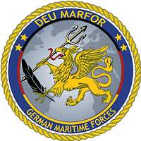 Rundes Abzeichen mit blauem Rand und mit einem Greif in der Mitte.