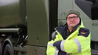Ein Tanklastwagenfahrer posiert vor seinem Lkw.