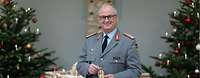 Generalinspektuer Zorn Generalinspekteur, Eberhard Zorn vor einer weihnachtlichen Dekoration mit Geschenken und Weihnachtsbäumen.