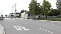 Zufahrt zur Wache beim Panzerpionierbataillon 701 Eine asphaltierte Straße läuft auf ein Wachhaus zu. Die Straße ist mit zwei Schlagbäumen gesperrt.