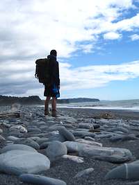 Axel Schönborn steht an einem Stein-Strand und blickt in die Ferne