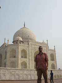 Axel Schönborn trägt eine Sonnenbrille und steht vor dem Taj-Mahal-Palast