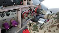 Zwei Tankschläuche sind am Flugzeug befestigt 