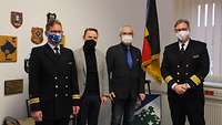 Zwei Zivilisten stehen zwischen zwei Soldaten zum Gruppenfoto. Alle tragen einen Mund-Nasen-Schutz.