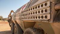 Eine Soldatin steigt in einen Transportpanzer 