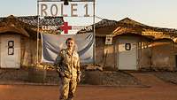 Eine Soldatin steht vor der Sanitätseinsatzstaffel in Gao, hinter ihr ein großes Schild mit der Aufschrift „Role 1“ 