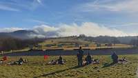 Soldaten liegen mit ihren Maschinengewehren auf einer großen Wiese, vor ihnen sind Zielscheiben aufgebaut.