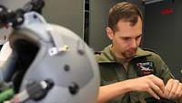 Der Helm eines Eurofighterpiloten wird durch einen Rettungsystemtechniker instandgesetzt.