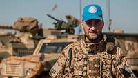 Ein Soldat steht vor einem militärischen Fahrzeug