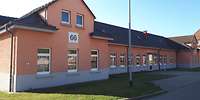 Ein einstöckiges, orangefarbenes Gebäude mit Giebeln