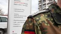 Vor dem John F Kennedy Haus der Vivantes Hauptstadtpflege ist die Schulter eines Hauptfeldwebels der Luftwaffe zu sehen.