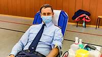 Brigardegeneral Pototzky liegt auf einer Liege und spendet Blut.