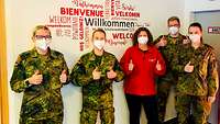 Zwei Soldatinnen, zwei Soldaten und eine zivile Mitarbeiterin des BRK zeigen ihre Daumen hoch.