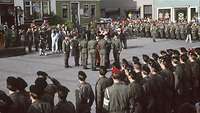 Soldiers stand in a square and make their solemn vows on the troop flag