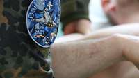 Physiotherapeutin bei NATO-Mission Eine Physiotherapeutin behandelt einen Soldaten an der Schulter.